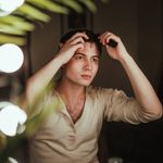 Actor touches up hair in dressing room mirror