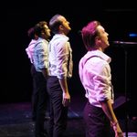 Rear shot of four men in white shirts with braces