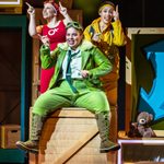 Three female characters sat on a wooden box