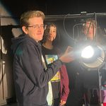 Diverse group of young children staring at the camera behind a lit spotlight