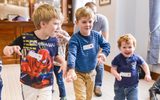 Three young boys can be seen smiling and having fun together whilst participating in one of our workshops.