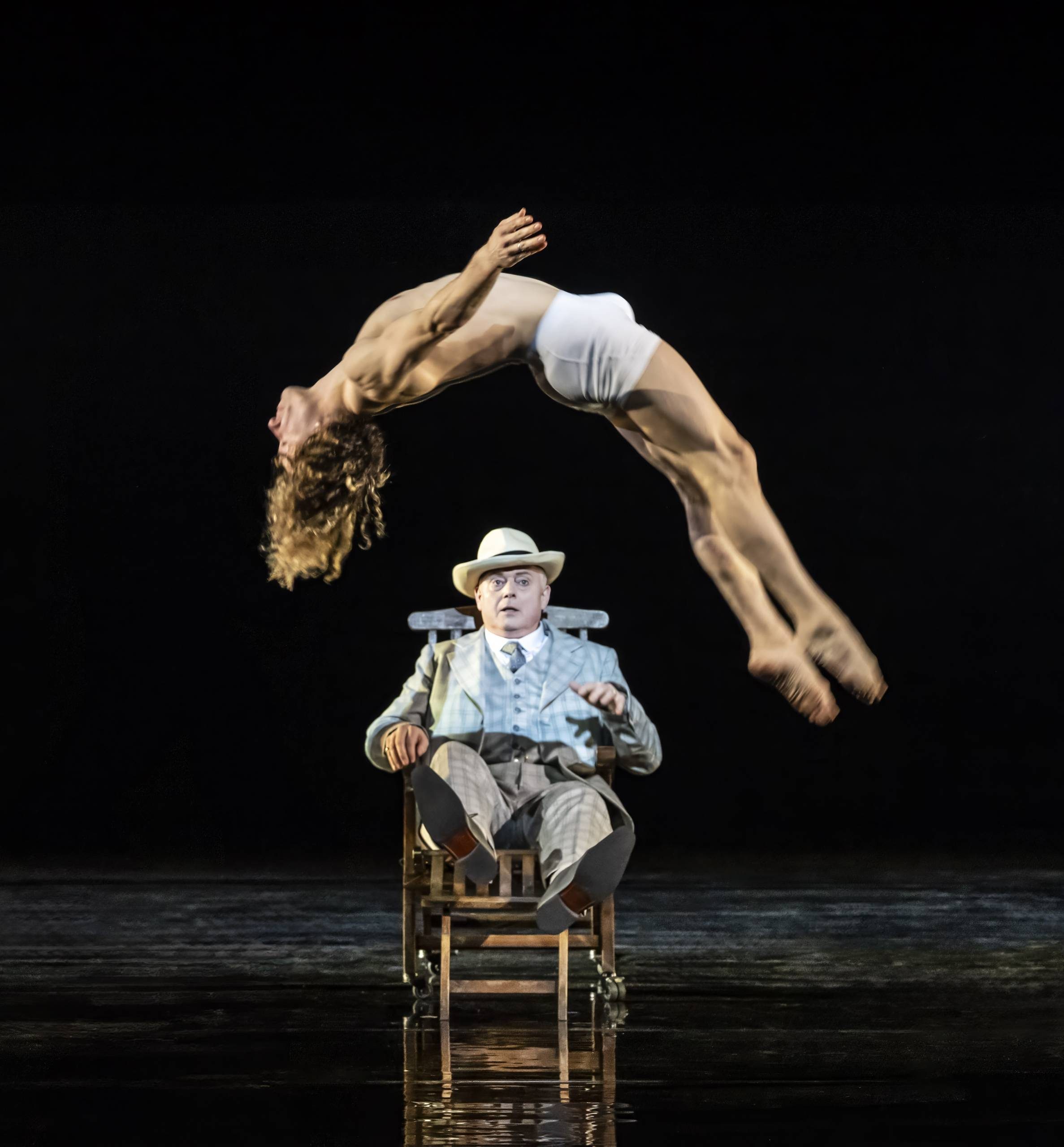 Aschebach (Mark le Brocq) watches entranced as Tadzio (Anthony Cesar) does a backwards flip before him.