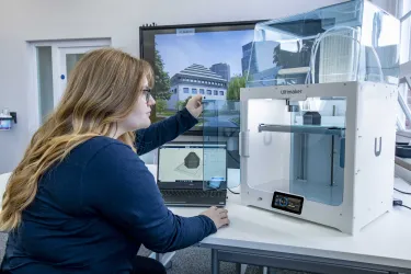 A student inspecting the finished construction of her latest 3D printed object.