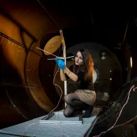 A student checks their experiment in the electric propulsion lab