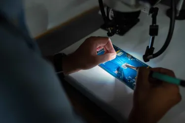 Person working on a circuit board