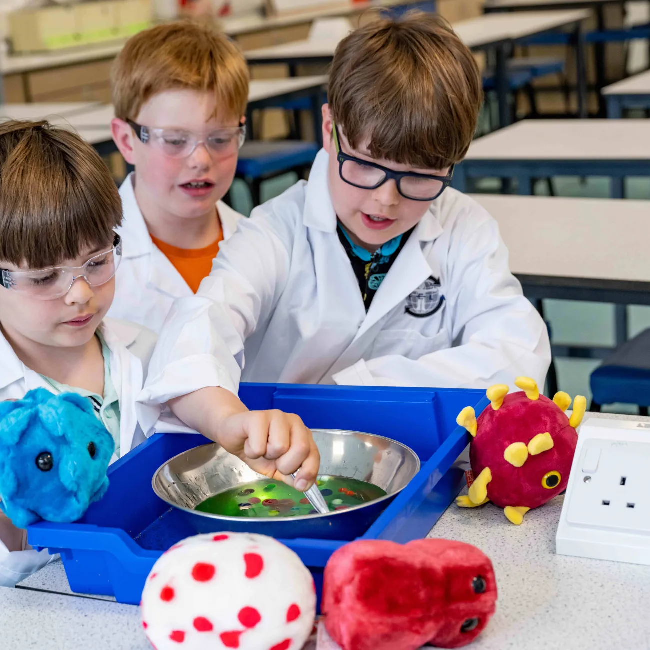 A group of primary school students doing educational activities around a classroom table.